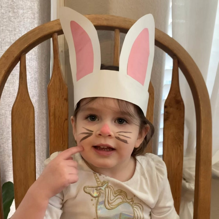 Child wearing paper cut-out bunny ears